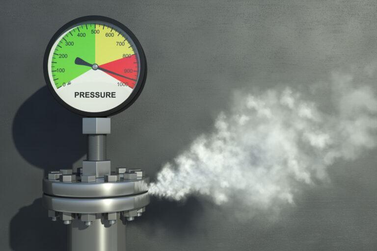 Gas or steam leaking from an industrial pressure gauge.